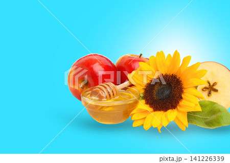Brightly colored apples and honey complement a sunflower on display 141226339