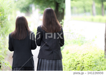 屋外の緑背景で笑顔で仲良しの日本人女子高校生 2人で過ごす高校生活と青春 顔無しの後姿 屋外の緑背景で笑顔で仲良しの日本人女子高校生 2人で過ごす高校生活と青春 顔無しの後姿 141226930