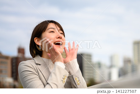 空に向かって呼びかける若い女性 空に向かって呼びかける若い女性 141227507