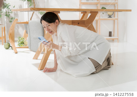 机の下に逃げる女性 141227558