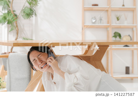 机の下に逃げる女性 机の下に逃げる女性 141227587