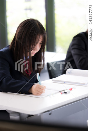 教室で真剣に勉強へ取り組む日本人女子高校生 受験や定期テストに向けて自習する学生 教室で真剣に勉強へ取り組む日本人女子高校生 受験や定期テストに向けて自習する学生 141227772
