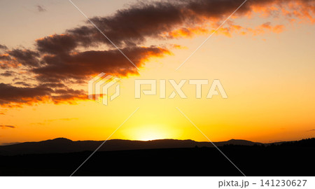 夏の北海道美瑛町の丘から見たオレンジ色に染まる日没間近の夕陽 141230627