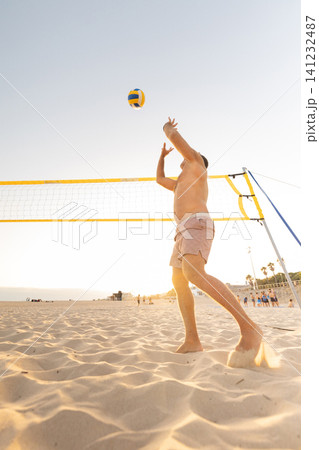 Man playing beach volleyball at sunset Man playing beach volleyball at sunset 141232487