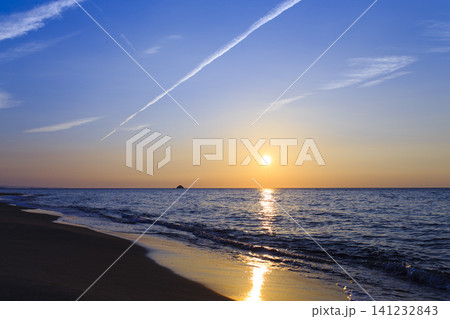 青空と夕日に照らされた静かな海岸風景 141232843