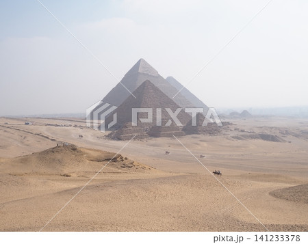エジプト・ギザ：砂漠にそびえ立つ三大ピラミッドとラクダが佇む広大な世界の絶景 141233378