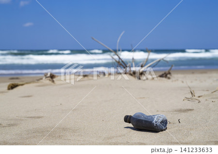 晴れた砂浜に落ちているペットボトルと青い海 晴れた砂浜に落ちているペットボトルと青い海 141233633