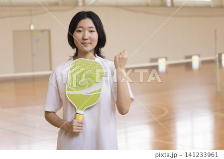 ピックルボールのパドルを持ってガッツポーズしている若い女性 141233961