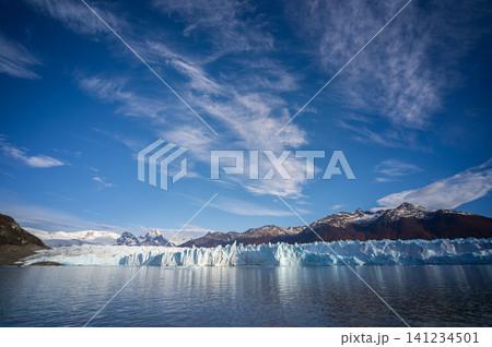 Perito moreno glacier patagonia los glaciares national park, blue ice wall above calm lake under wide sky Perito moreno glacier patagonia los glaciares national park, blue ice wall above calm lake under wide sky 141234501