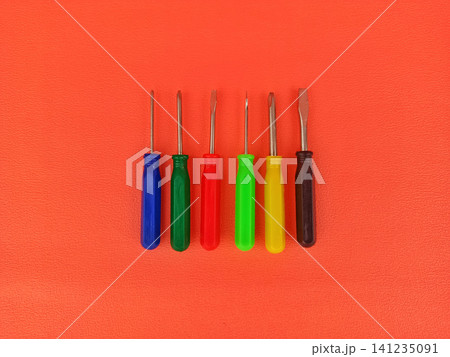 Set of Colorful Screwdrivers Lying on Orange Background 141235091