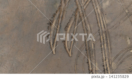 Aerial view wheel tire track on mud, Tire mark imprints on mud vehicles tires footprints transport ground trace or marks textures, wheel treads, Mud terrain. Aerial view wheel tire track on mud, Tire mark imprints on mud vehicles tires footprints transport ground trace or marks textures, wheel treads, Mud terrain. 141235829