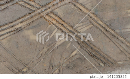 Aerial view wheel tire track on mud, Tire mark imprints on mud vehicles tires footprints transport ground trace or marks textures, wheel treads, Mud terrain. Aerial view wheel tire track on mud, Tire mark imprints on mud vehicles tires footprints transport ground trace or marks textures, wheel treads, Mud terrain. 141235835