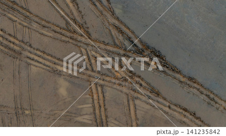 Aerial view wheel tire track on mud, Tire mark imprints on mud vehicles tires footprints transport ground trace or marks textures, wheel treads, Mud terrain. Aerial view wheel tire track on mud, Tire mark imprints on mud vehicles tires footprints transport ground trace or marks textures, wheel treads, Mud terrain. 141235842