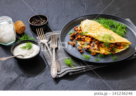 Egg omelet with fried wild chanterelles and dill 141236246