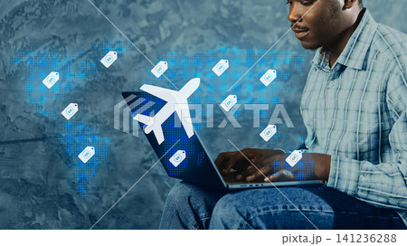 Person booking travel online while sitting on a chair with a laptop 141236288