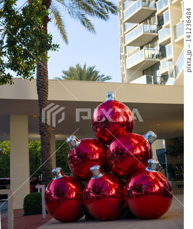 Red Ornament Sculpture Beneath Palm Trees Near a Building Red Ornament Sculpture Beneath Palm Trees Near a Building 141236484