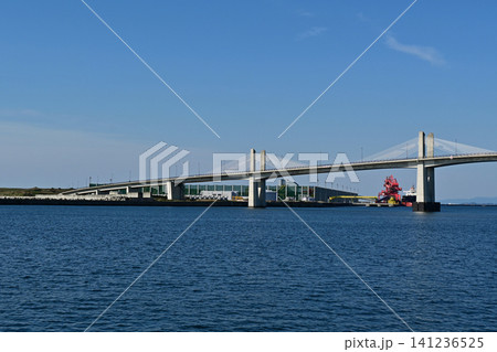 快晴の小名浜港に迫る小名浜マリンブリッジのランプ道路と港湾インフラの美しい遠景 快晴の小名浜港に迫る小名浜マリンブリッジのランプ道路と港湾インフラの美しい遠景 141236525
