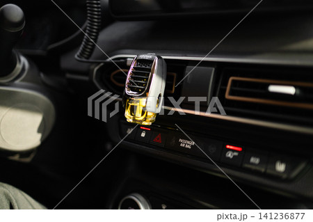 Car air freshener attached to the ventilation grill on a dashboard. Car air freshener attached to the ventilation grill on a dashboard. 141236877