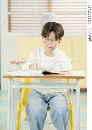 Boy studying quietly in a bright elementary classroom 141237184