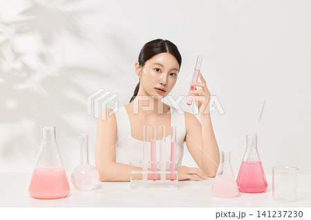 Woman examining cosmetic ingredients in flasks for a skincare concept Woman examining cosmetic ingredients in flasks for a skincare concept 141237230
