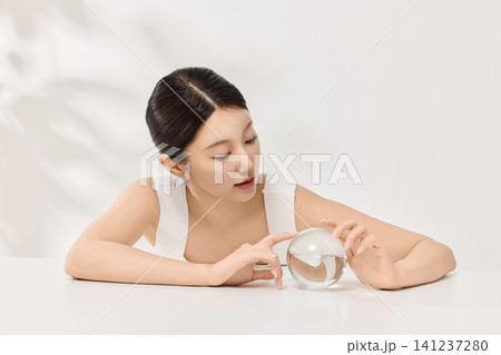 Woman applying serum with a dropper for a skincare routine 141237280