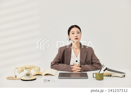 Asian businesswoman working at a white office desk with a laptop 141237312