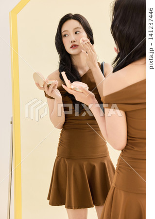 Woman styling a brown dress with a coat and handbag Woman styling a brown dress with a coat and handbag 141237446