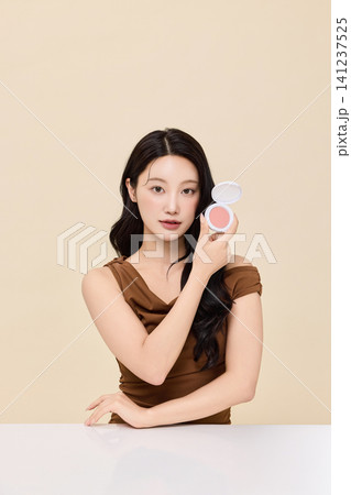 Asian woman presenting cosmetic palette during a makeup routine Asian woman presenting cosmetic palette during a makeup routine 141237525