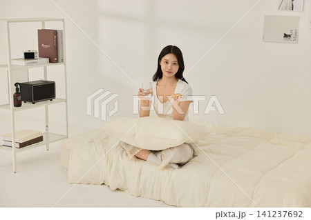 Young Asian woman drinking water on a bed in the morning 141237692