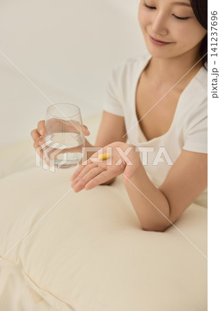 Young Asian woman drinking water on a bed in the morning 141237696