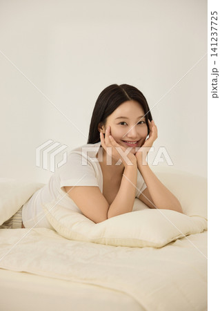 Morning wake-up concept with a woman and alarm clock Morning wake-up concept with a woman and alarm clock 141237725