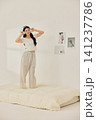 Playful morning lifestyle portrait with a woman on a cream bed 141237786