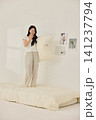 Asian woman posing with a pillow in a white bedroom 141237794