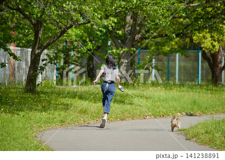 春の公園で可愛いポメラニアンの子犬を抱っこして散歩する私服の十代の女の子の姿 春の公園で可愛いポメラニアンの子犬を抱っこして散歩する私服の十代の女の子の姿 141238891