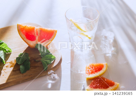 Soft focus grapefruit drink scene with mint, ice and bright summer reflections 141239165