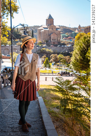 Young traveler in a straw hat looking away near a historic monastery 141239217