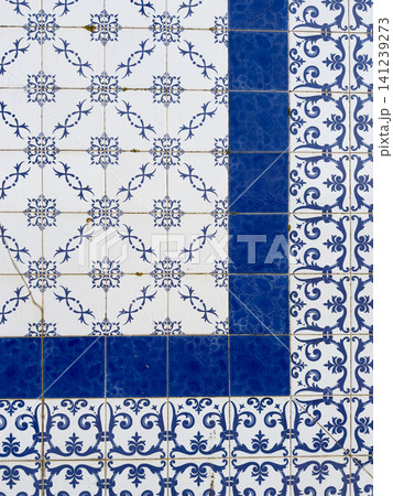 Portuguese azulejos pattern featuring white tiles with intricate blue floral motifs contrasted by bold dark blue border tiles forming a geometric frame Portuguese azulejos pattern featuring white tiles with intricate blue floral motifs contrasted by bold dark blue border tiles forming a geometric frame 141239273
