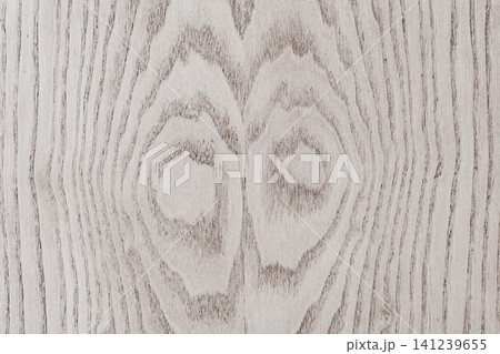 Full frame background texture of a light grey natural oak wood board with a beautiful symmetrical ring grain pattern and knots visible on a polished surface 141239655