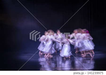 Dancers performing an expressive circular movement on stage 141239975
