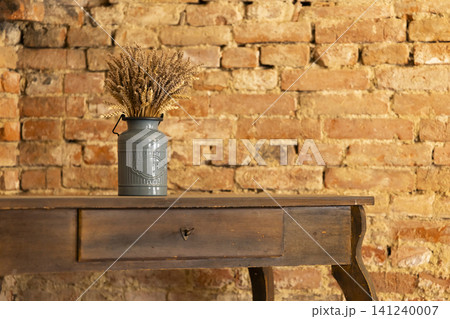 Dried wheat in vintage milk can on wooden table Dried wheat in vintage milk can on wooden table 141240007