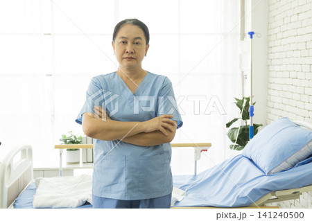 Asian female nurse standing and smile looking to camera in hospital. 141240500