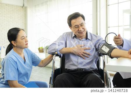 Doctor examine and measuring blood pressure of old Asian patient in hospital. Doctor and nurse diagnose patient in hospital. Doctor examine and measuring blood pressure of old Asian patient in hospital. Doctor and nurse diagnose patient in hospital. 141240728