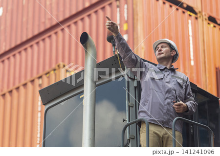 Happy Winner manager, Foreman shipping staff working at Container cargo rising hand and pointing finger for Win in Logistic Business. Leader stand on above container. Happy Winner manager, Foreman shipping staff working at Container cargo rising hand and pointing finger for Win in Logistic Business. Leader stand on above container. 141241096