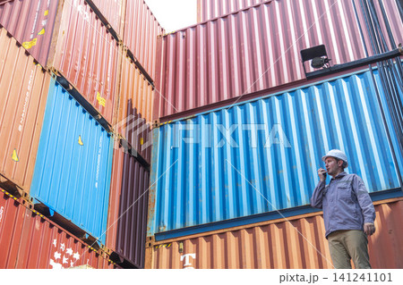 Happy Winner manager, Foreman shipping staff working at Container cargo rising hand and pointing finger for Win in Logistic Business. Leader stand on above container. Happy Winner manager, Foreman shipping staff working at Container cargo rising hand and pointing finger for Win in Logistic Business. Leader stand on above container. 141241101