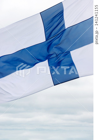 Closeup of the Finnish flag waving strongly against an overcast sky. Motion blur. Copy space. Closeup of the Finnish flag waving strongly against an overcast sky. Motion blur. Copy space. 141241155