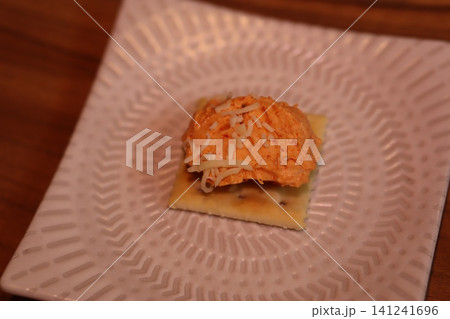 Cracker with Orange Cheese Dip and Shredded Cheese 141241696