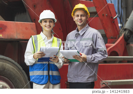 Two engineers discussing project together with construction worker outdoors 141241983