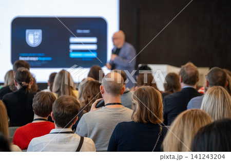 Business conference presentation with attentive audience listening to speaker during professional seminar and networking session Business conference presentation with attentive audience listening to speaker during professional seminar and networking session 141243204