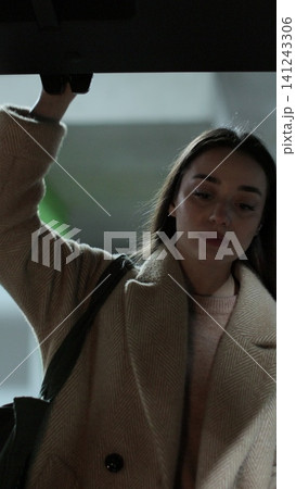 Vertical video Close-up woman opens the trunk of car and puts paper bags. Shooting from inside the car. Vertical video Close-up woman opens the trunk of car and puts paper bags. Shooting from inside the car. 141243306