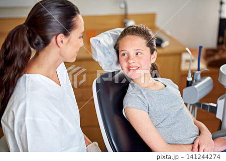Dentist, child and oral hygiene consultation with conversation and talk for dental care. Clinic, smile and young girl with healthcare and wellness advice for mouth and teeth health at appointment Dentist, child and oral hygiene consultation with conversation and talk for dental care. Clinic, smile and young girl with healthcare and wellness advice for mouth and teeth health at appointment 141244274